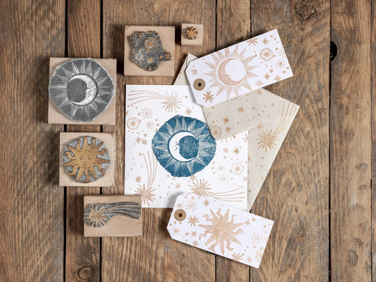 A collection of Noolibird wooden block rubber stamps displaying various cosmic designs including wonky stars, shooting stars, and outline moons.